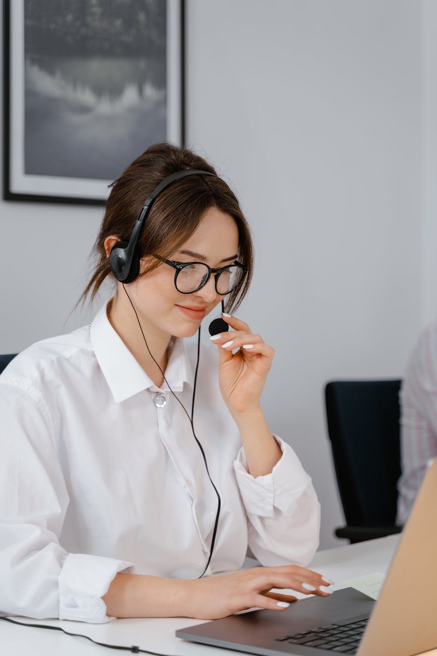 a woman wearing a headset while working on a laptop